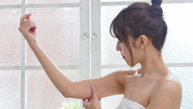 リビングで二の腕を摘む女性