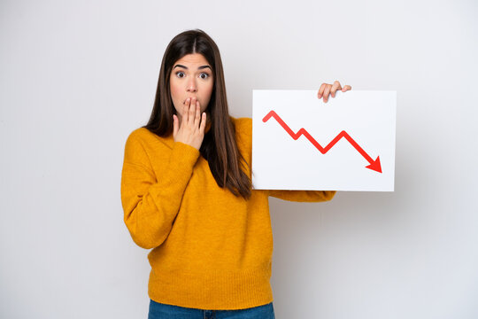 Young Brazilian woman isolated on white background holding a sign with a decreasing statistics arrow symbol with surprised expression