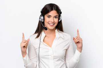 Telemarketer caucasian woman working with a headset isolated on white background pointing up a great idea