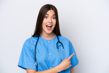Young Brazilian nurse woman isolated on white background surprised and pointing side
