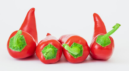 A group of delicious red and hot peppers with shiny skins isolated with clipping path on a white background.