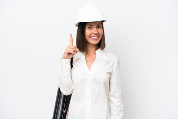 Young architect woman with helmet and holding blueprints isolated on white background showing and lifting a finger in sign of the best
