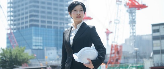 ヘルメットを持つスーツを着た日本人女性