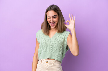 Young caucasian woman isolated on purple background showing ok sign with fingers