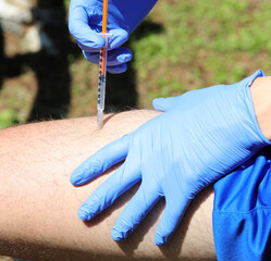 boy with blue gloves while injecting insulin dose on his thigh because he has diabetes