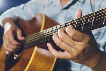 Fototapeta na wymiar Closeup of hand playing acoustic guitar