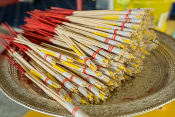 sacrificial and ceremony sets made from candles and incense wrapped in paper in temple Thailand