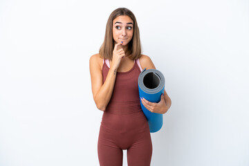 Fototapeta premium Young sport caucasian woman going to yoga classes isolated on white background having doubts and thinking
