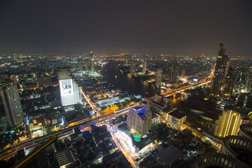 Fototapeta na wymiar Night traffic road light with city building aerial view