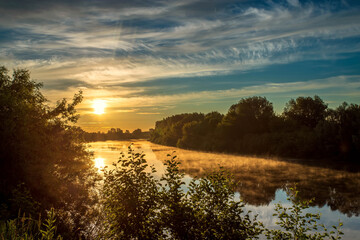 Summer sunrise over the river. Calm, relaxing rural landscape.