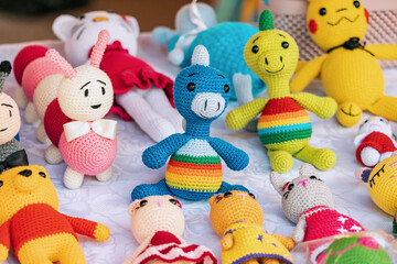 Fototapeta na wymiar Various knitted funny toys for children are sold at the hand made market.