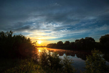 Summer sunrise over the river. Calm, relaxing rural landscape.