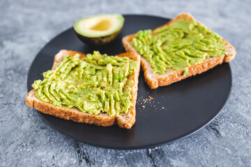 healthy plant-based food, basic plant-based smashed avocado toast with half avocado next to it