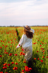 Happy woman in the blooming poppy field.  Nature, vacation and lifestyle.