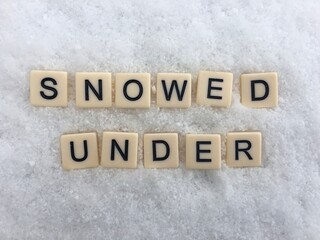 Words snowed under written on snowy background