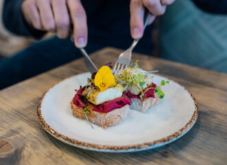 Close up of cool man having healthy toast for breakfast in a healthy coffee shop.