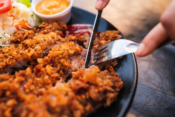 Pork batter with potato sticks and mayonnaise on a black plate