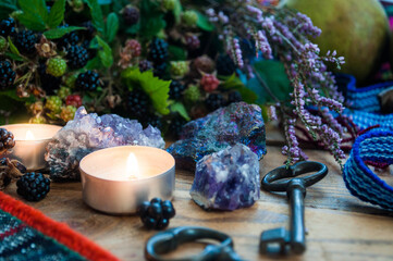 Cozy autumn still life. Branches of blackberries and heather in a basket, lighted candle and...