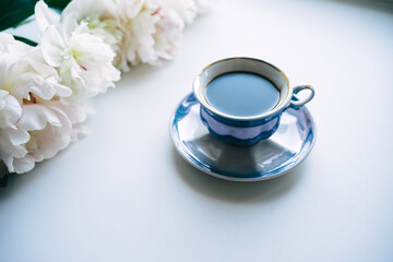 a beautiful postcard. a white coffee cup with bouquet of white peonies
