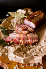 Meat on a plate. Smoked meat on a wooden board. Sliced ham on a plate. Sliced ham and bacon. Ham and salami. Pieces of chopped bacon.