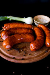 Sausages for grilling. Sausages board. Sausages on a black background. Tasty and juicy, natural grilled sausages.