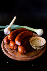 Sausages for grilling. Sausages board. Sausages on a black background. Tasty and juicy, natural grilled sausages.