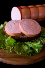 sausage on a plate. sausage and salad. meat and sausage. Cooked sausage. Pieces of sausage on black bread. 