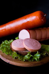 sausage on a plate. sausage and salad. meat and sausage. Cooked sausage. Pieces of sausage on black bread. 