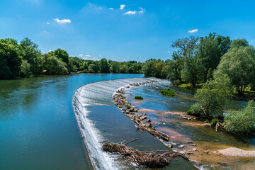 Germany, Nuertingen city next to riverside of neckar river water in summer on sunny day with blue sky, panorama view above little waterfall, tourism destination