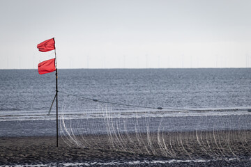 Stellnetz mit roten Fahnen bei Ebbe an Nordseestrand