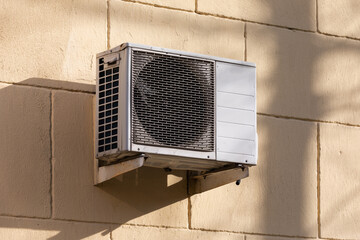 outdoor unit of a domestic air conditioner with a fan outside the building