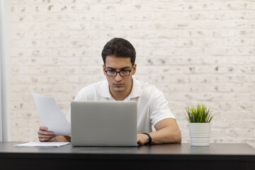 Young businessman working on laptop at home. Distant work concept