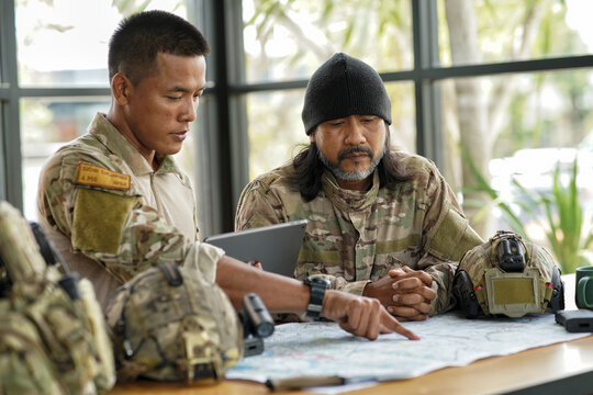 army ranger special force discussion looking pointing at the war map on table and GPS to mark up location plan before attact enemy
