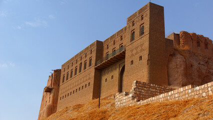 A red citadel on a yellow hill under a bright blue sky