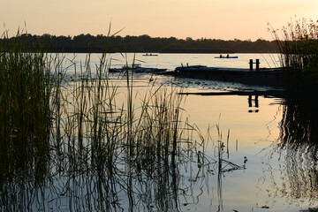Pier in reeds overlooking kayaks on a wide river