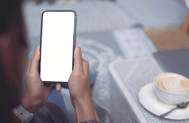 Cell phone mockup image blank white screen.  Woman hand holding, using mobile phone at home.