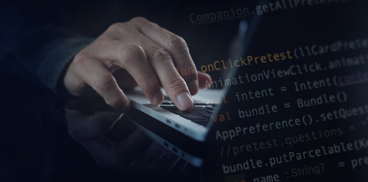 Software development, developing programmer coding javascript on laptop computer and using mobile phone for mobile apps design in software company office, digital technology