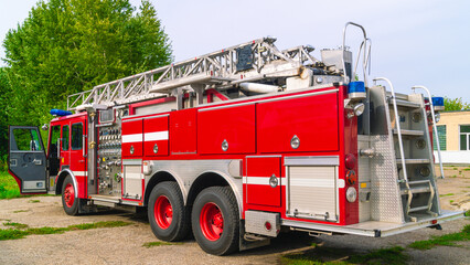 A fire truck with a retractable ladder for the delivery of firefighters to the place of fire and...