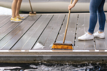 Cleaning Pier on Lake or Sea Beach. Pier Service  Yacht or Boat concept. Washing Pier floor with Brush