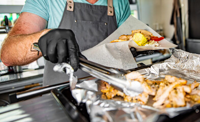 process of preparing traditional greek fast food - gyros. chef hand cooking food on kitchen