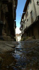 Fototapeta na wymiar water running between the old houses of a pretty village