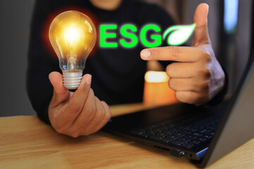 People holding orange light bulbs and it's creative to do business in ESG or environment social...