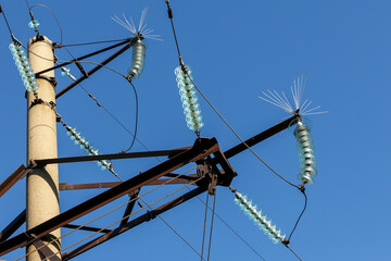Concrete electricity pylon with glass insulators and bird spikes. Electric power concept. Bird...