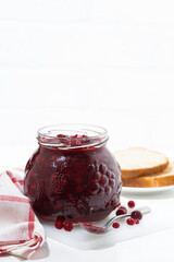 jar of cranberry jam on a white table, vertical