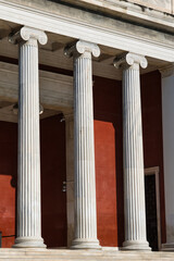 Tall columns of a traditional building in Athens, Greece form the entrance area to a Museum. Traditional, impressive greek building style. 