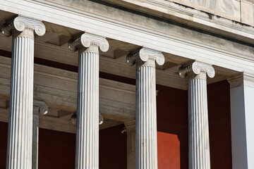 Close-up photo of big, tall columns on a traditional style greek building in Athens, Greece form...
