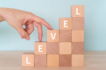 レベルのイメージ｜「LEVEL」と書かれたブロックと手