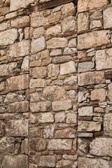 Abstract picture of an old, ancient brick stone wall in Athens, Greece, with multiple rows of small and big bricks and a metal element on top. Textured background. 