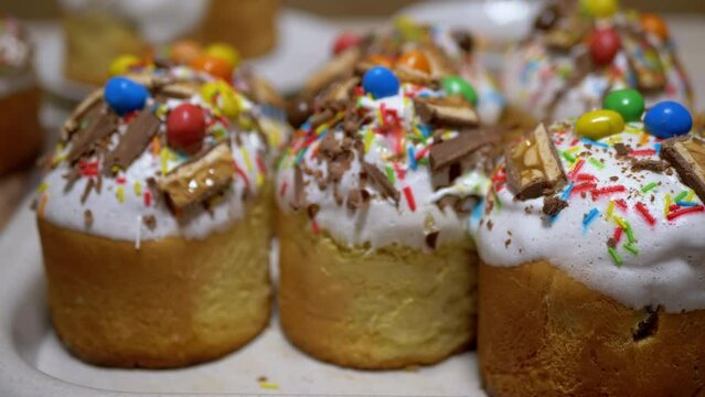 Many Colorful Easter Cupcakes Decorated with White Icing, Pieces of Chocolate. Delicious, rich homemade cakes, decorated with topping, eggs, nuts, confetti, powder. Orthodox religion event, Easter.