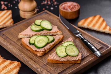 Delicious fresh sandwich with chicken liver pate with crispy toast, butter and cucumber